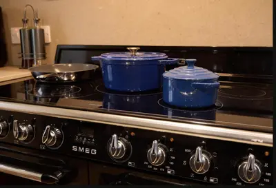two blue pots and pans sitting on top of a stove at ISLE OF GIGHA FARM HOUSE in Isle of Gigha