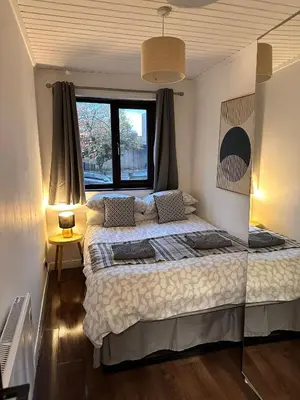 a bedroom with a large bed and a window at BrightCentral Apartment With Parking in Glasgow