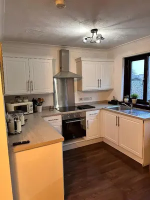a kitchen with white cabinets and a stove top oven at BrightCentral Apartment With Parking in Glasgow