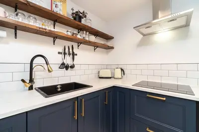 a kitchen with blue cabinets and a sink at Stylish City Pad with Free Private Parking in Glasgow