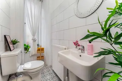 a white bathroom with a toilet and a sink at Traditional 1-Bed Flat in Southside (Hampden/Shawlands) in Glasgow