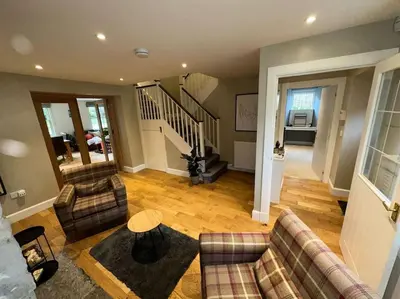 a living room with two couches and a staircase at The Gate House - 3 Bed & Parking in Edinburgh