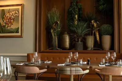 a dining room with a table with glasses and plants at Crieff Hydro in Crieff