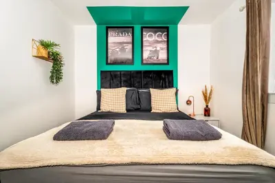 a bedroom with a large bed with a green headboard at Sleek and Stylish 3 Bed in Greenock - Sleeps 8 in Greenock