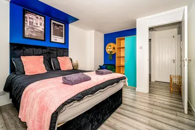 a bedroom with blue walls and a large bed at Sleek and Stylish 3 Bed in Greenock - Sleeps 8 in Greenock