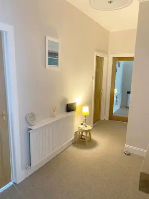 a living room with a table and a lamp at Waverley Apartments, The Wheelhouse in Gourock