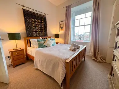 a bedroom with a large bed and a window at Garnethill Charm 3 Bed Flat Central Glasgow in Glasgow
