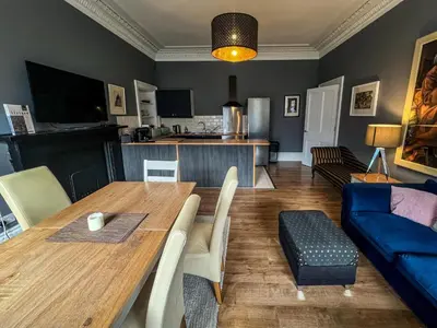 a living room with a table and a blue couch at Garnethill Charm 3 Bed Flat Central Glasgow in Glasgow