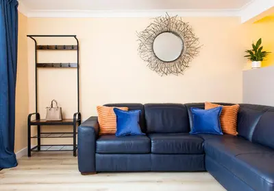 a blue couch in a living room with a mirror at The Apartment at No.12 in Lochwinnoch