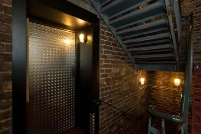 a bathroom with a brick wall and lights at CODE - The Loft, Edinburgh in Edinburgh