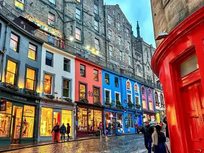 a group of people walking down a street with buildings at E'holidays in Edinburgh