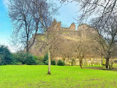 a castle sitting on top of a lush green field at E'holidays in Edinburgh