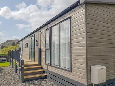 a large wooden trailer with stairs and windows at Ben Vorlich Lodge in Saint Fillans
