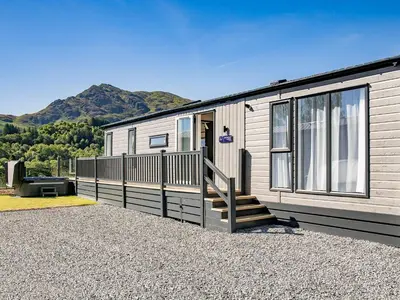 a mobile home with a staircase leading to the front door at Ben Vorlich Lodge in Saint Fillans