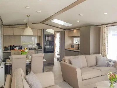 a living room with a couch and a kitchen at Ben Vorlich Lodge in Saint Fillans