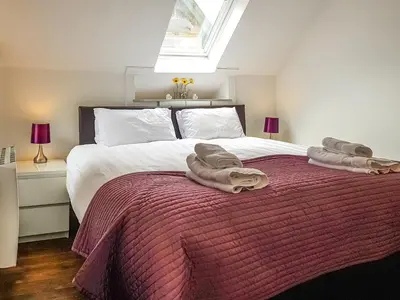 a bedroom with a bed with towels on it at Craigdarroch Cottage in Saint Fillans