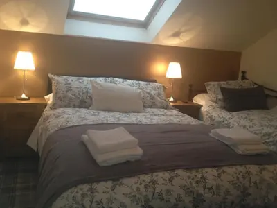 a bedroom with a large bed with towels on it at Glengorm Guest House in Oban