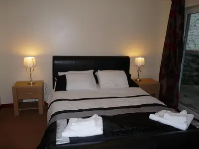 a bedroom with a large bed with two night stands at Glengorm Guest House in Oban