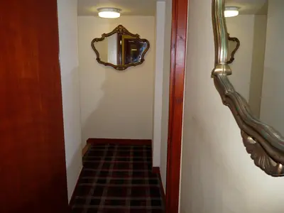 a hallway with a mirror on the wall and a staircase at Glengorm Guest House in Oban