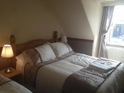 a bedroom with a bed and a lamp and a window at Glengorm Guest House in Oban