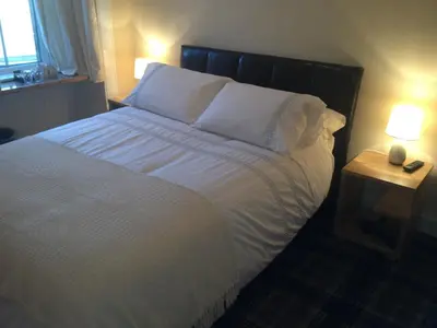 a bedroom with a bed with white sheets and pillows at Glengorm Guest House in Oban
