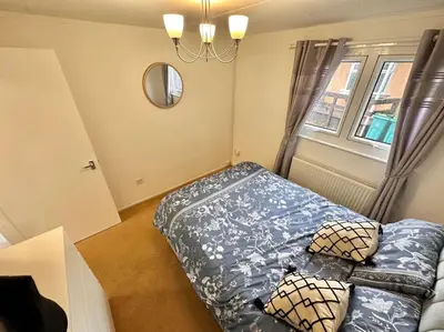 a bedroom with a bed and a mirror and a window at Semi-detached 1-Bedroom Chalet at Maryville Caravan Site - Uddingston, Glasgow in Uddingston