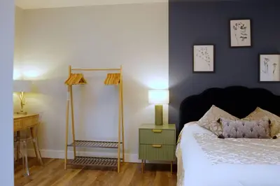 a bedroom with a bed and a table with a lamp at Stunning Coach House in Largs