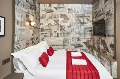 a bedroom with a white bed with red pillows at The Pier Rooms in Oban