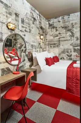 a bedroom with a bed and a mirror and a red chair at The Pier Rooms in Oban