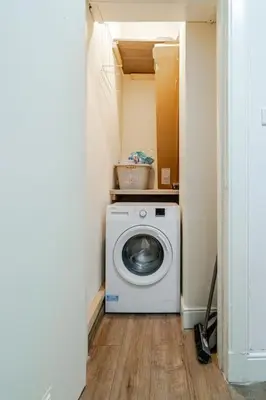 a laundry room with a washing machine in a hallway at Stunning Ground Floor flat in Southside. in Glasgow