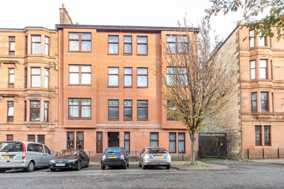 a group of cars parked in front of a building at Stunning Ground Floor flat in Southside. in Glasgow