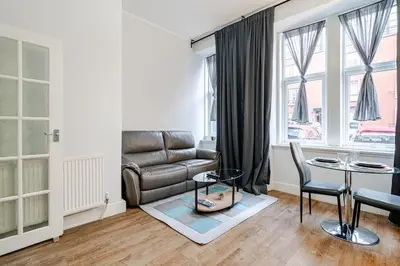 a living room with a couch and a table at Stunning Ground Floor flat in Southside. in Glasgow