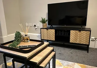 a living room with a tv and a coffee table at Trendy West End Apartment, Glasgow in Glasgow