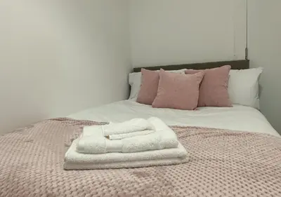 a pile of towels sitting on top of a bed at Trendy West End Apartment, Glasgow in Glasgow