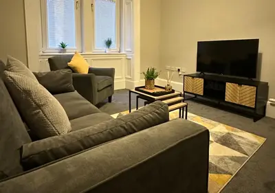 a living room with two couches and a flat screen tv at Trendy West End Apartment, Glasgow in Glasgow
