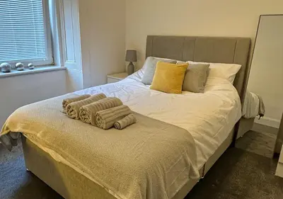 a bedroom with a large bed with towels on it at Trendy West End Apartment, Glasgow in Glasgow