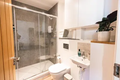 a bathroom with a shower and a toilet and a sink at Barnet House Serviced Apartments in Dunfermline