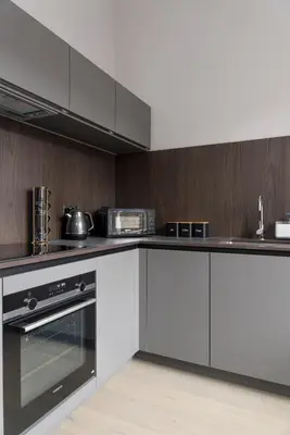 a kitchen with white appliances and wooden walls at Modern George Street Studio sleeping 2 in Edinburgh