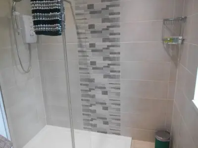 a shower with a glass door in a bathroom at Eliburn Woodside Lodge in Livingston