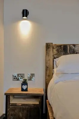 a bedroom with a bed and a table with a plant on it at Campbell Street Apartments in Oban