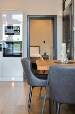 a dining room with a table and chairs and a bed at Campbell Street Apartments in Oban