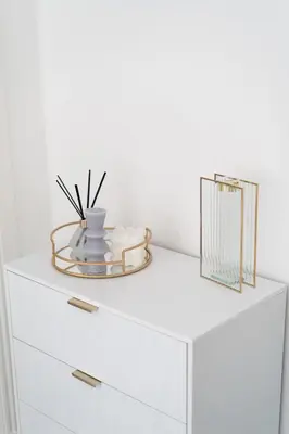 a white chest of drawers with a vase on it at Coatbridge Apartment in Coatbridge