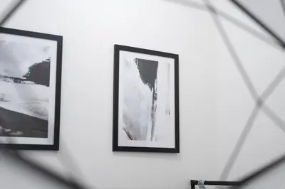 two framed photographs on a wall in a mirror at Coatbridge Apartment in Coatbridge