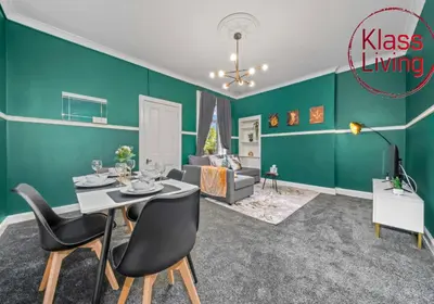 a living room with green walls and a table and chairs at Alexander Apartment by Klass Living Coatbridge in Coatbridge