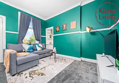 a living room with green walls and a couch at Alexander Apartment by Klass Living Coatbridge in Coatbridge