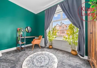 a room with a green wall and a window with plants at Alexander Apartment by Klass Living Coatbridge in Coatbridge