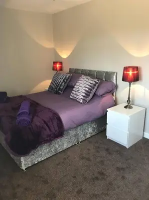 a bedroom with a bed with pillows and a lamp at Inishroel Cottage in Campbeltown
