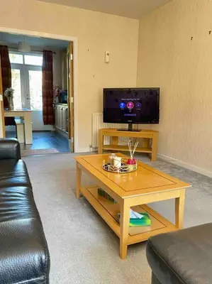 a living room with a coffee table and a tv at The Naburn - 3 Bed House with Free Parking & Close to City Centre in Glasgow
