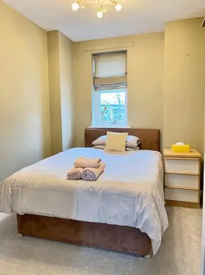 a bedroom with a bed with towels on it at The Naburn - 3 Bed House with Free Parking & Close to City Centre in Glasgow