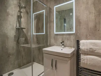 a bathroom with a shower and a sink and a mirror at 1 Bed in Callander oc-pe173 in Strathyre